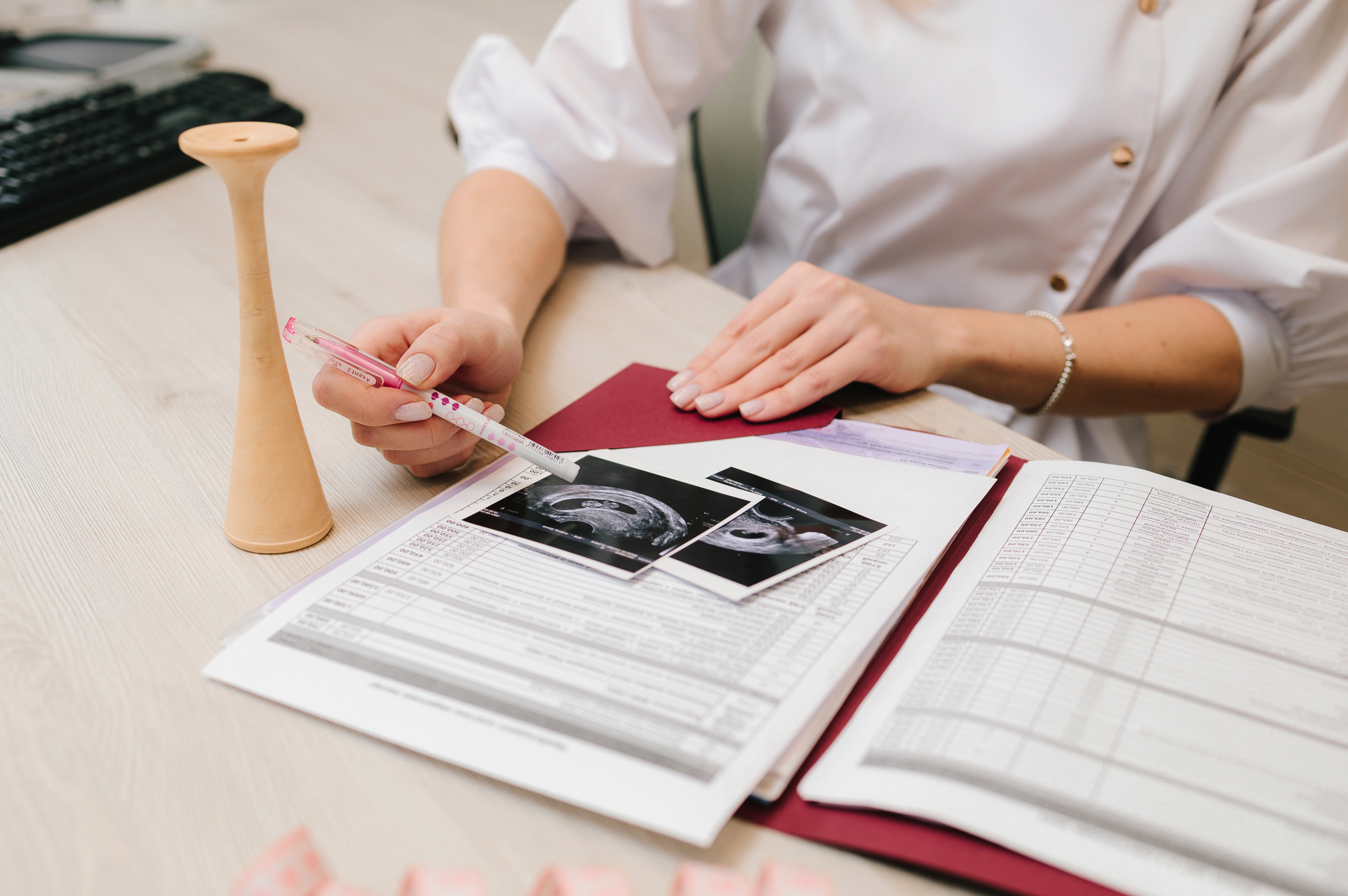 Doctor reviewing ultrasound reports and medical records during an obstetrics and gynaecology consultation.