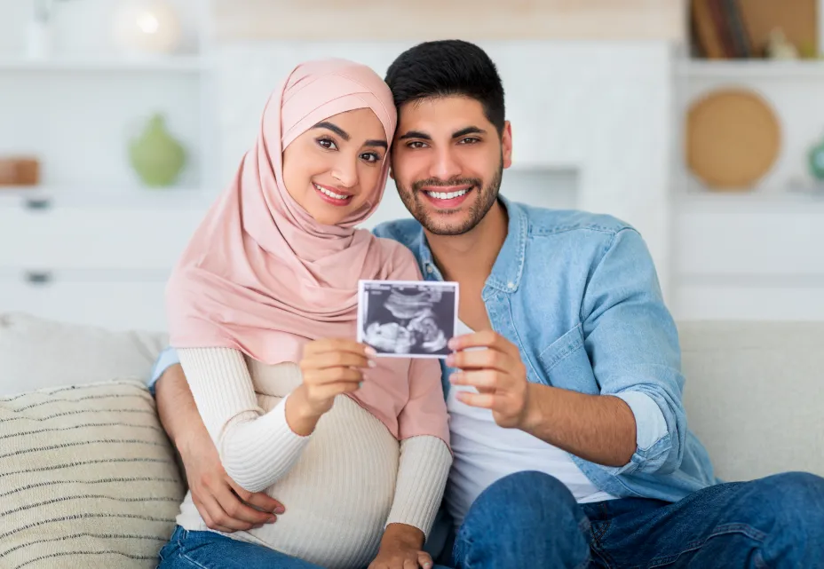 Couple holding an ultrasound image during IVF treatment.