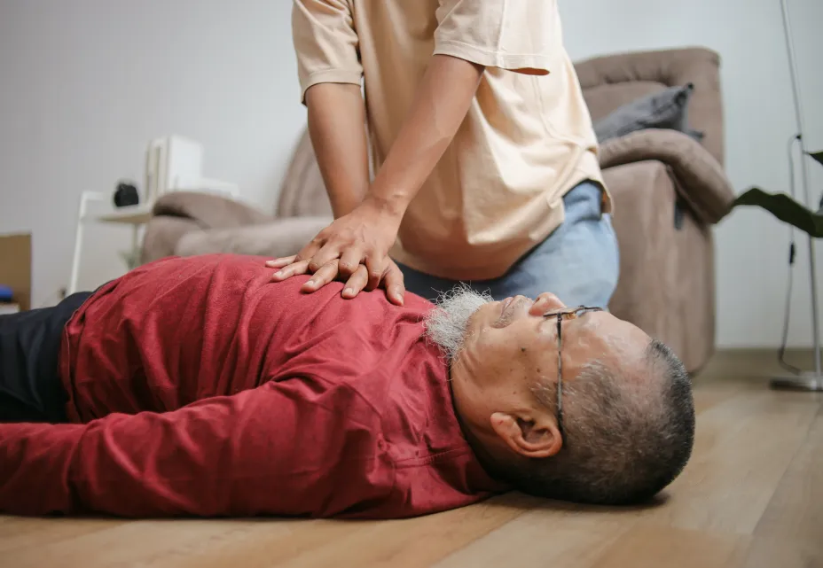 Person performing CPR on a man during a heart attack.